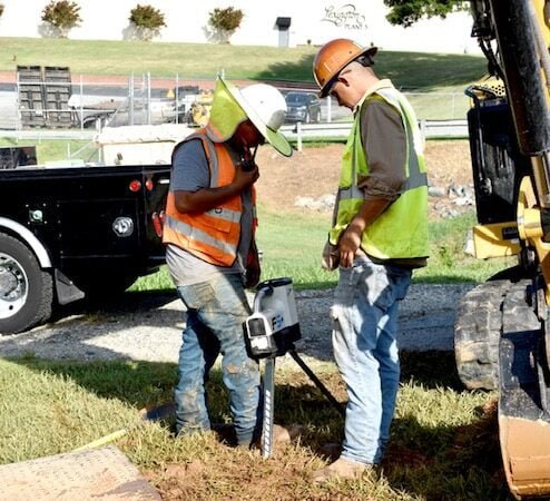 Tyler & employee interacting on what should happen next. They are determining if the width and depth is deep enough.  